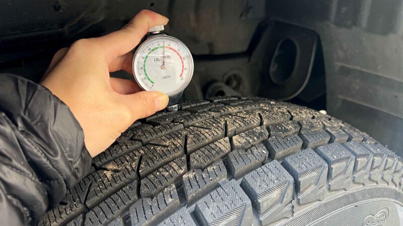 タイヤに硬度計を押し当てて計測中の様子。針が55付近を指している。