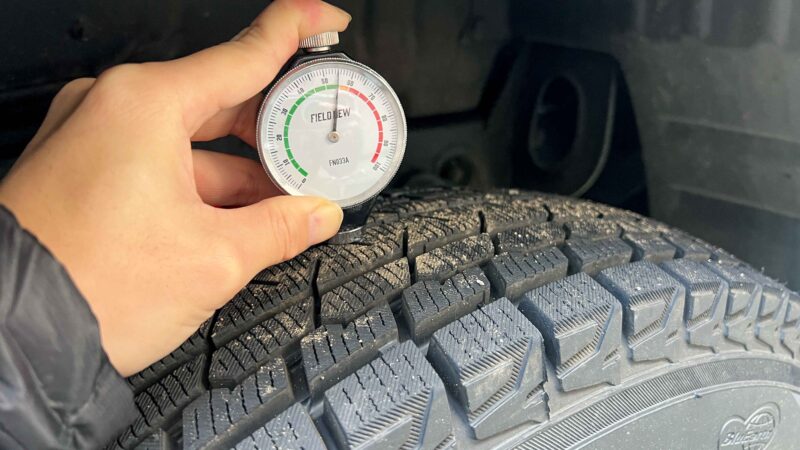 タイヤにFieldNew硬度計を押し当てている手元のアップ。針が緑ゾーン付近を指している。