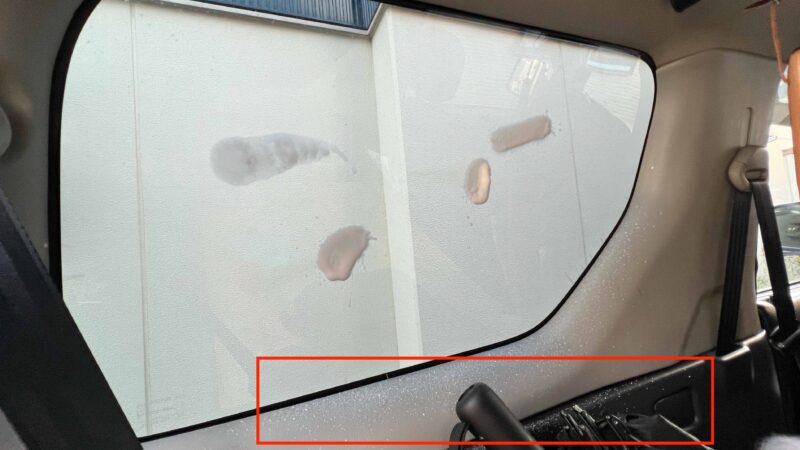 車内で窓ガラスに直接スプレーしている様子（飛び散りあり）